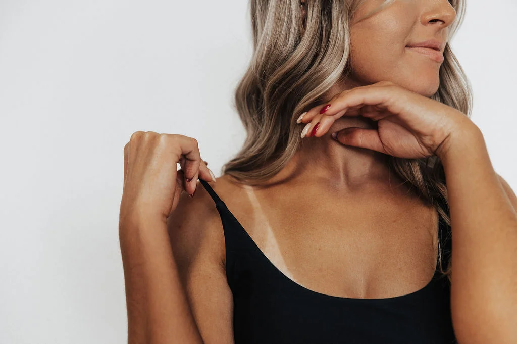 Spray tan artist at work in a professional setting.